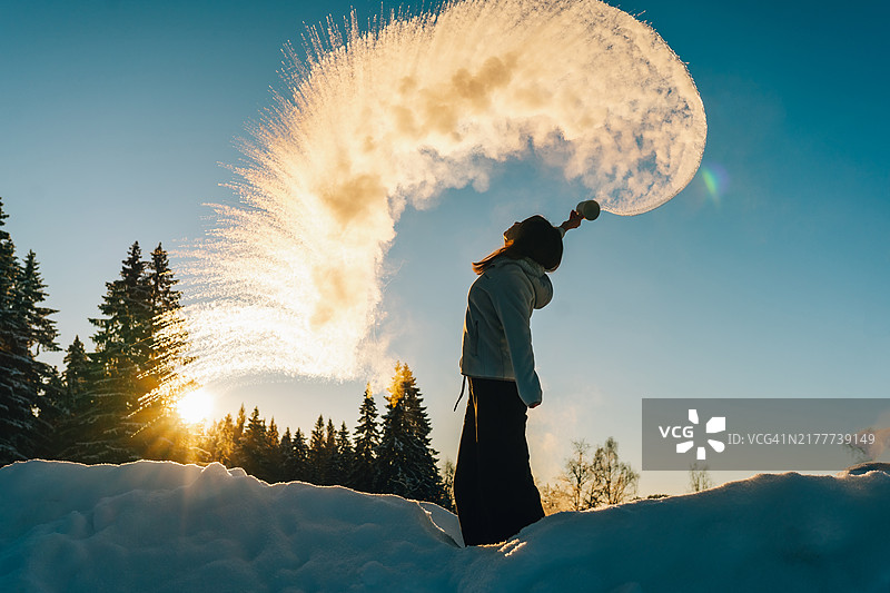 冬季奇观：女人制造水汽，倾倒开水，演示冷凝科学图片素材