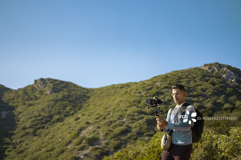 摄影师在户外用三脚架拍摄图片素材