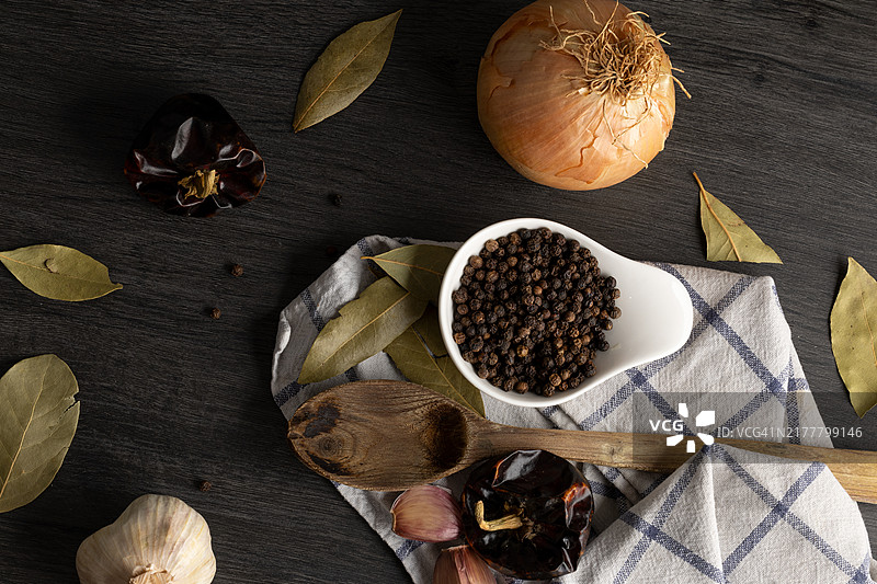 厨房中的新鲜食材：胡椒、大蒜、洋葱和月桂叶，为菜肴增添特别风味。图片素材