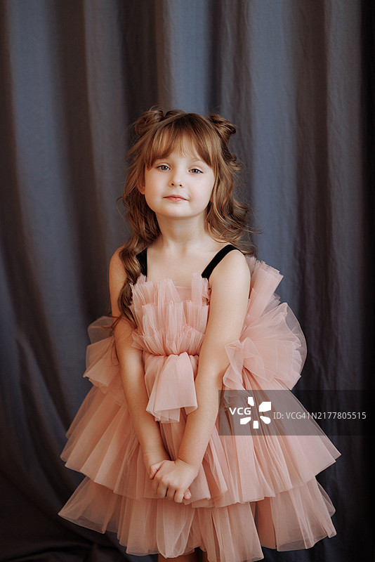 扎着辫子、身穿粉色连衣裙的女孩图片素材