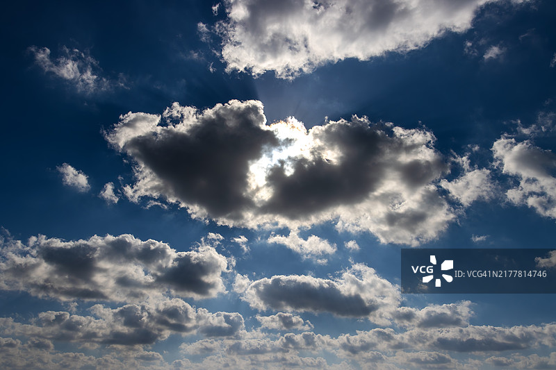 低角度视图，阳光透过云层洒下图片素材