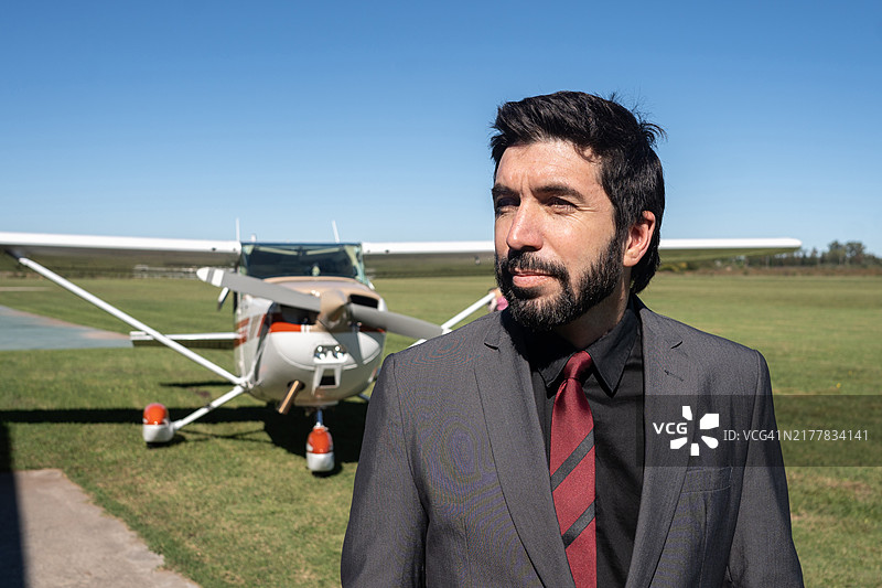 成熟的商人在飞机库内图片素材