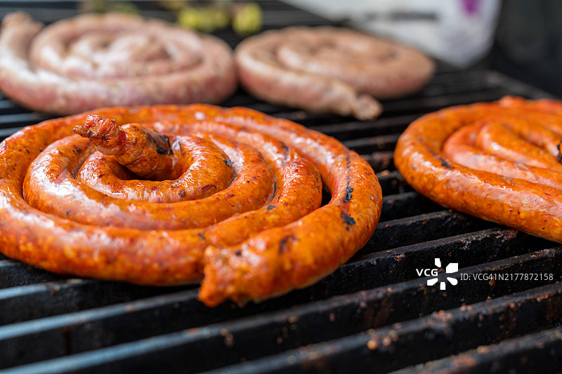 烤架上滋滋作响的甜辣意大利香肠图片素材