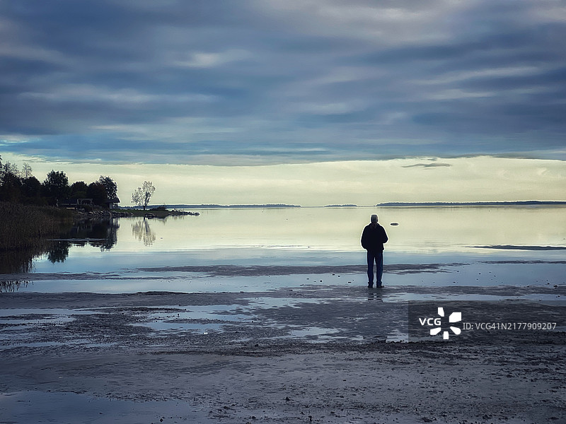 宁静海岸线边沉思的孤独身影图片素材