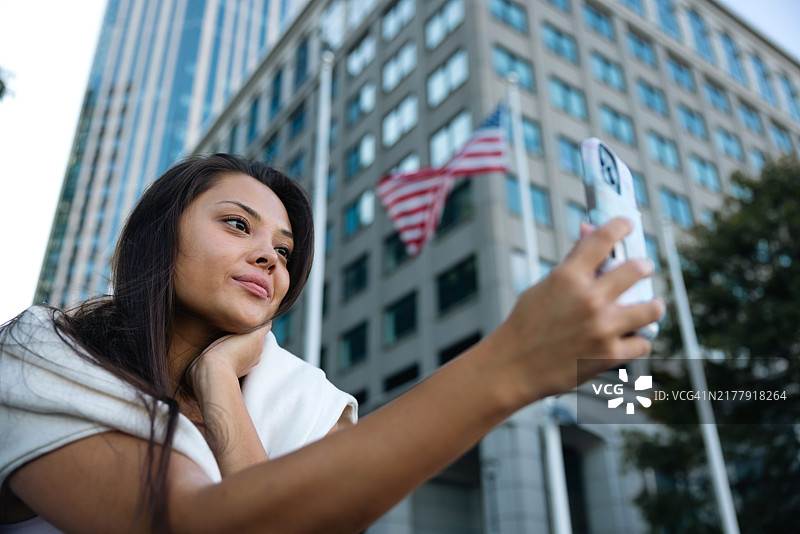 坐在户外用手机发短信的年轻Gen Z女性图片素材