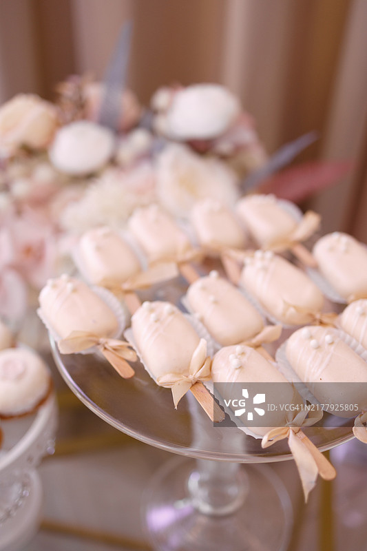 可爱的迷你冰淇淋形状糖果放在甜点架上。图片素材