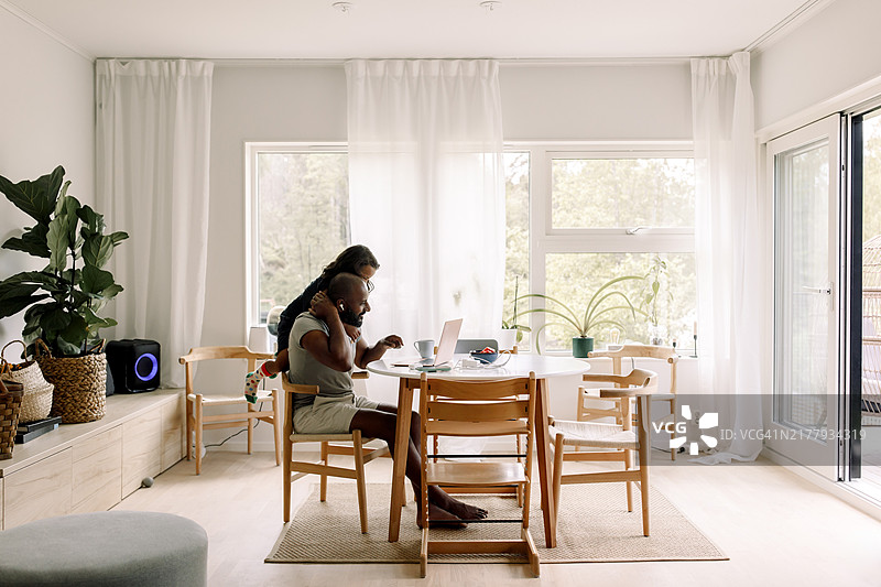 儿子在家中干扰父亲工作图片素材
