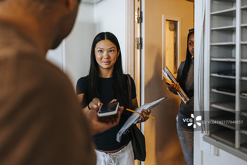 教授没收教室门口女学生的智能手机图片素材