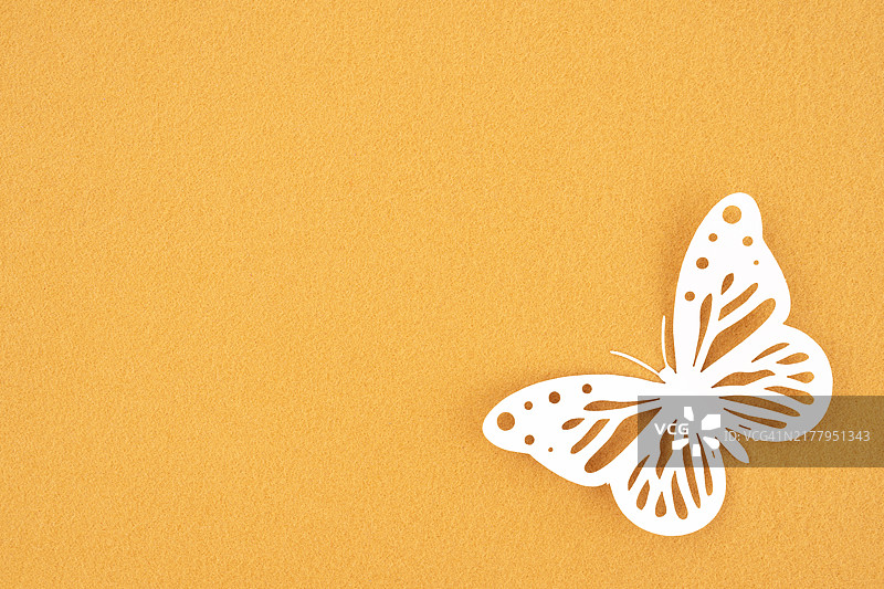 黄色背景上的白色蝴蝶剪纸，带有设计文案空间图片素材