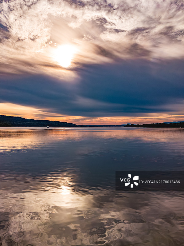 在宁静的湖面上航行的孤独游艇图片素材