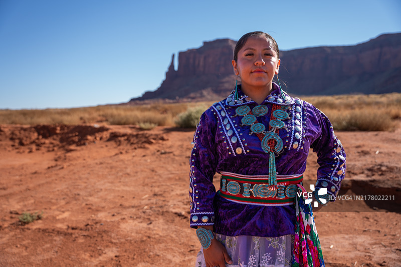 纪念碑谷犹他州阳光明媚的一天，身着传统服装的美丽纳瓦霍族妇女的宽幅肖像图片素材