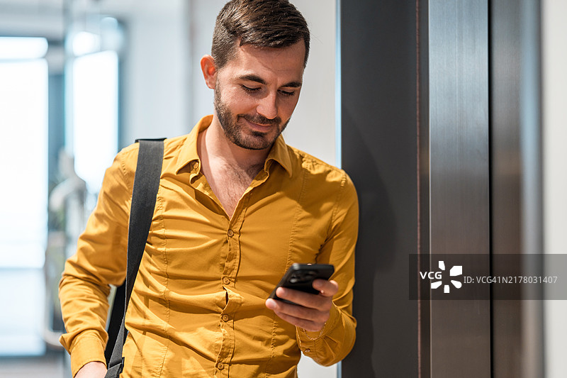 商人使用智能手机等待电梯图片素材