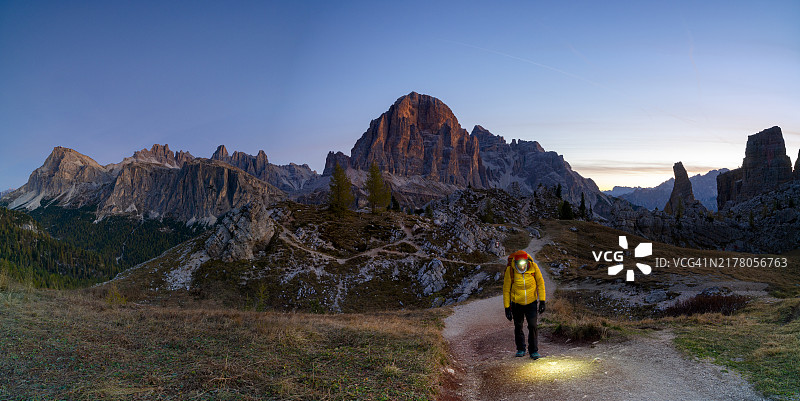 黄昏时分在多洛米蒂山小路上行走的孤独徒步者图片素材