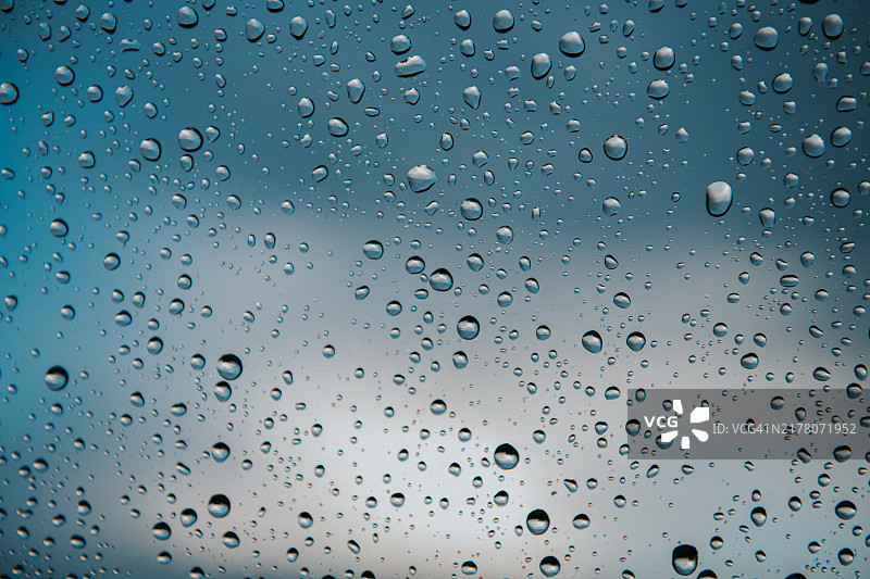 雨滴在窗格上反射阴天天空的抽象背景图像图片素材