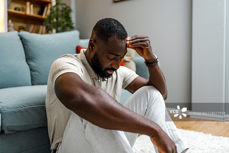 独自坐在地板上的沮丧男子图片素材