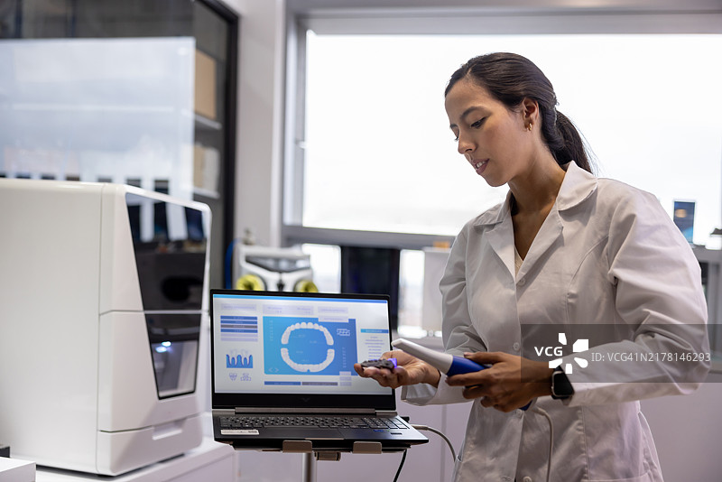 健康：工程师在实验室扫描3D牙科植入物图片素材