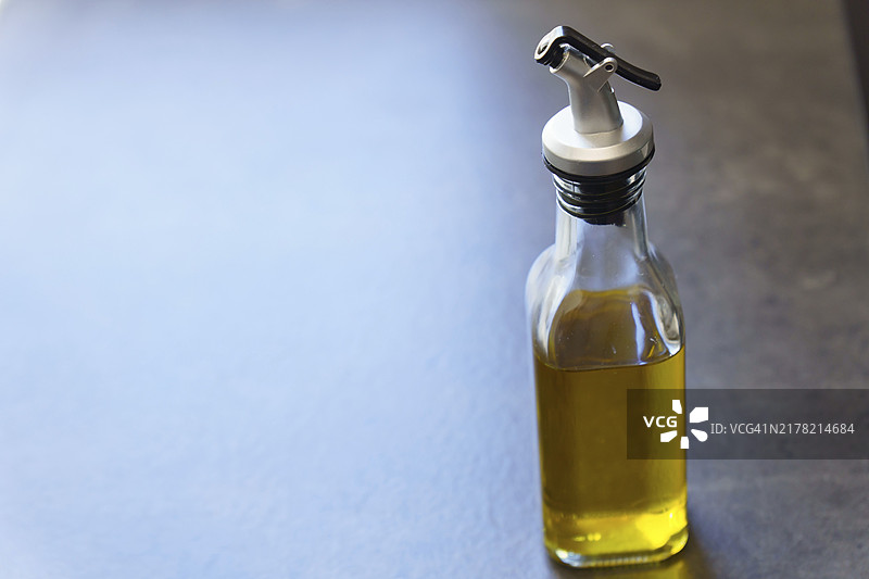 蓝色灯光桌面上特级初榨橄榄油玻璃罐图片素材