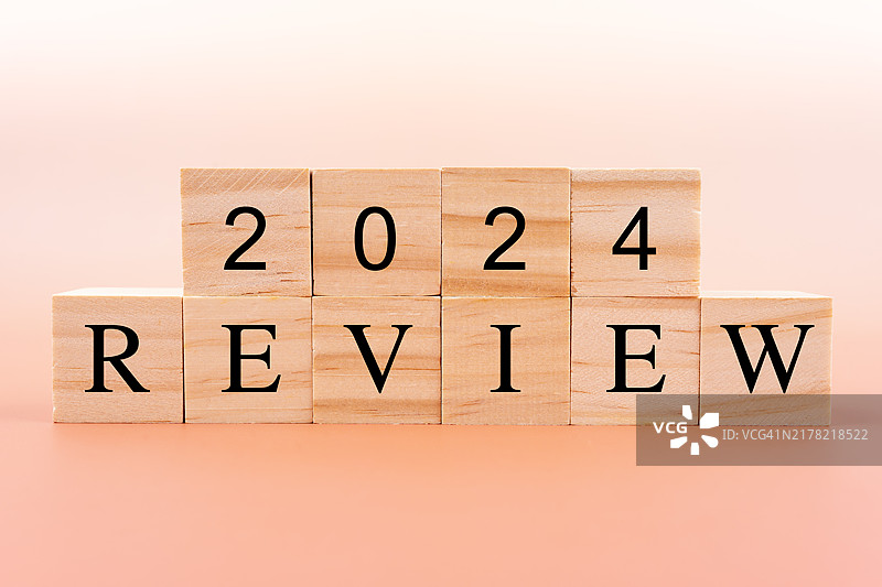 黄色背景上的2024年木制积木与审查文本图片素材