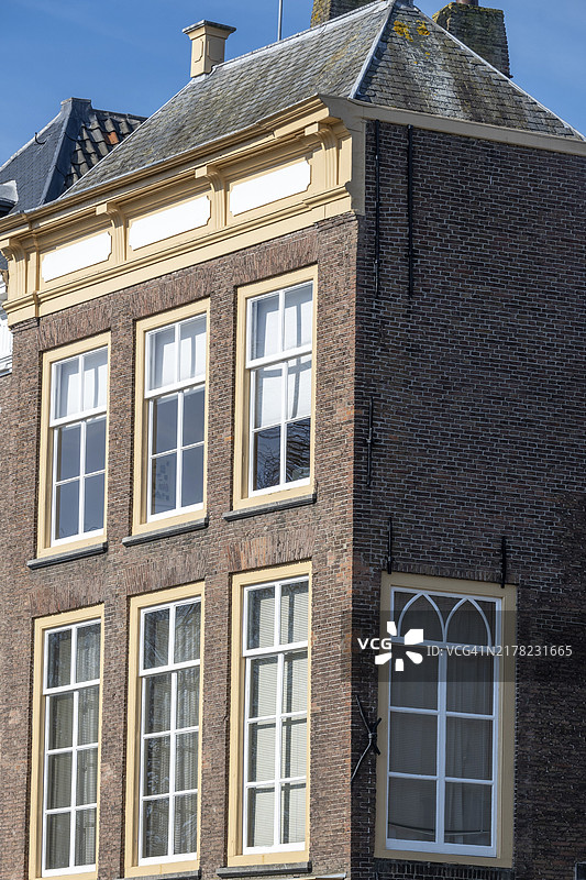 荷兰泽兰省米德尔堡一栋带山墙屋顶和多个窗户的旧砖砌建筑的侧面图片素材
