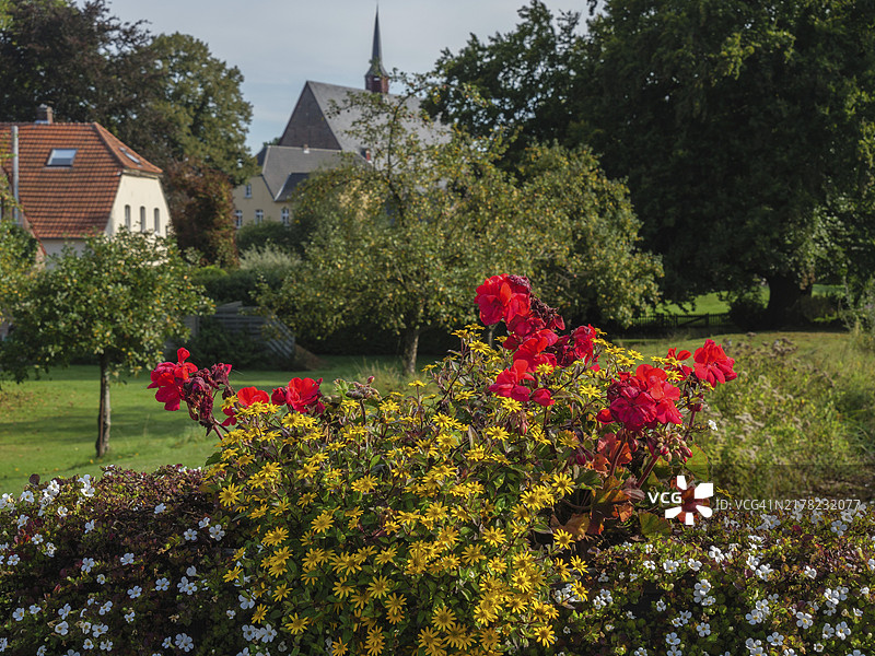 前景中的花朵：德国马林塔尔的乡村教堂与运河图片素材