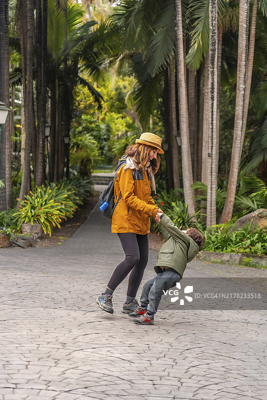 热带植物园中，母亲和儿子开心游玩，家庭度假图片素材