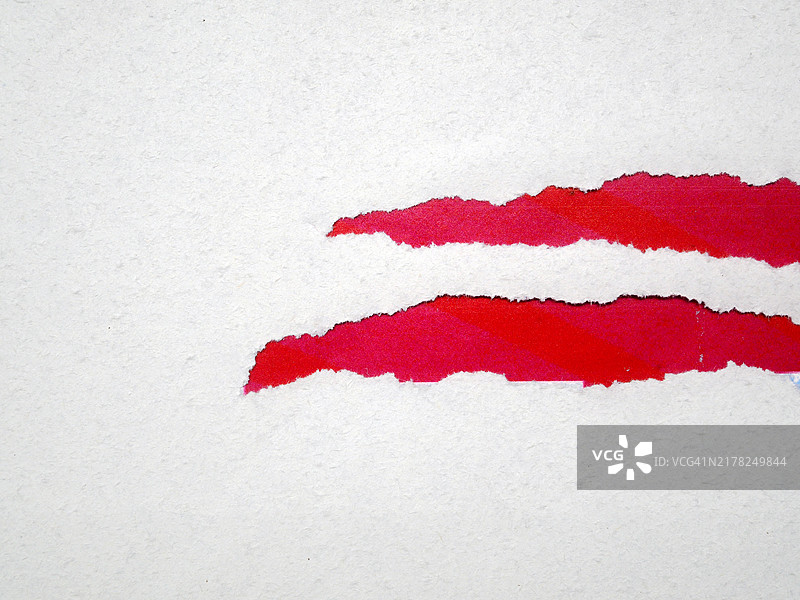 红色背景上的纹理撕裂白纸图片素材
