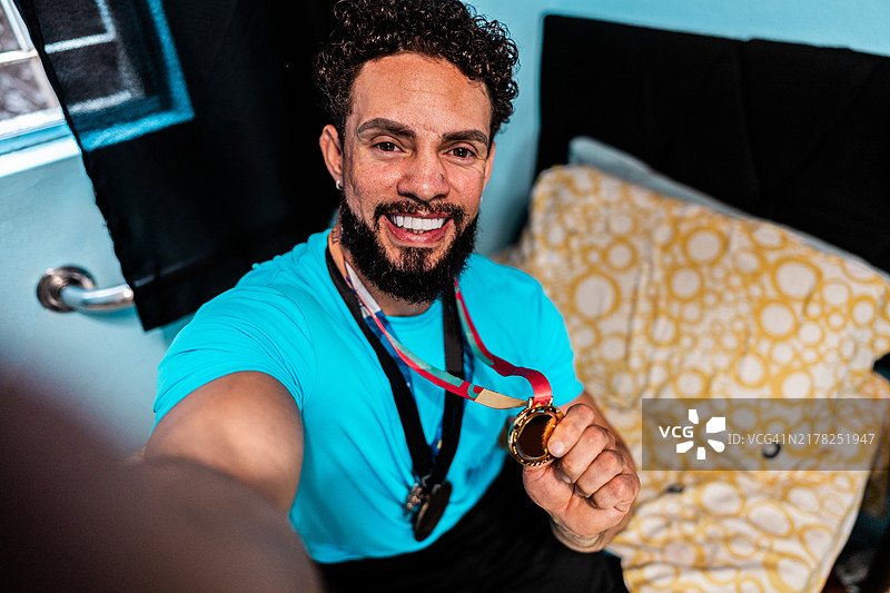 中年男子在家中自拍，展示他的奖牌 - 摄像机视角图片素材