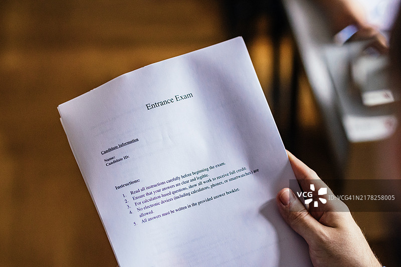 手持入学考试卷的特写图片素材