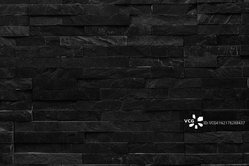 黑色涂漆砖墙，伴随自然光和阴影。图片素材