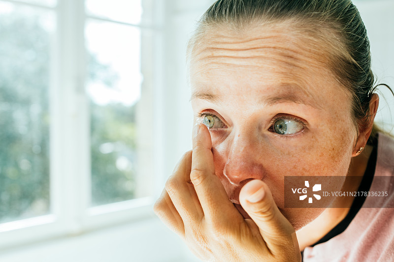 女人在浴室里戴隐形眼镜图片素材