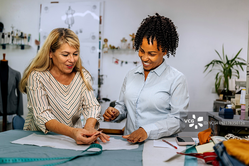 两位女性服装设计师在小型裁缝工作室工作图片素材