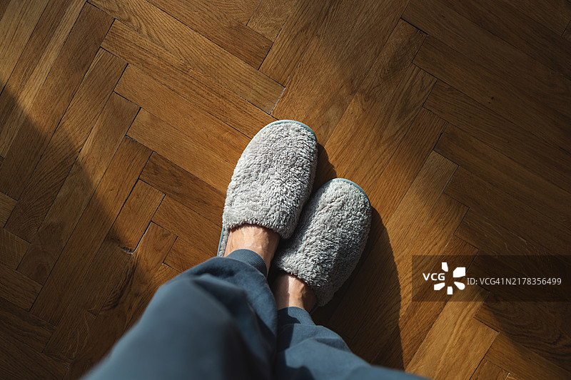 灰色裤子和灰色家居拖鞋的腿部俯瞰图片素材