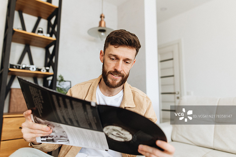 在家选择黑胶唱片的男人图片素材