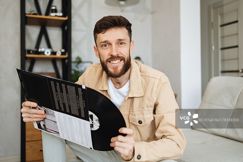手持黑胶唱片的英俊男士肖像图片素材