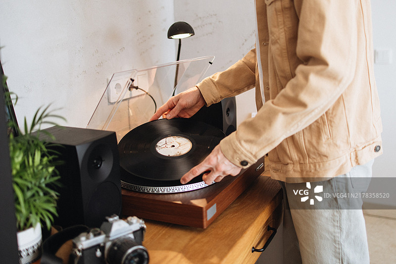 在播放器上放置黑胶唱片的男人图片素材
