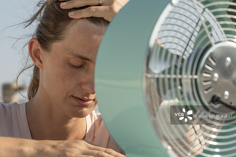 女人在风扇前乘凉图片素材