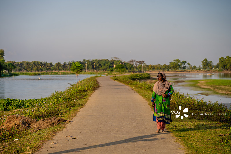 孟加拉国斯里曼甘尔的乡村风景小路上行走的女性图片素材