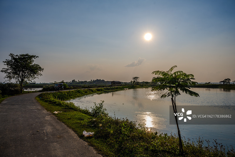孟加拉国斯里曼甘的河岸边宁静的乡村道路在日落时分图片素材