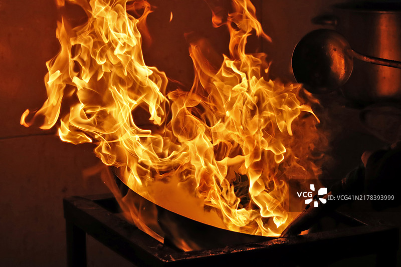 厨房里炒锅正在烹饪绿色蔬菜图片素材