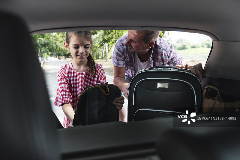 快乐的父亲和微笑的女儿收拾行李准备去度暑假图片素材
