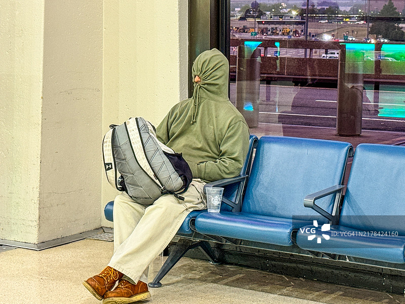 在纽瓦克机场座位上睡觉的蒙面男子图片素材