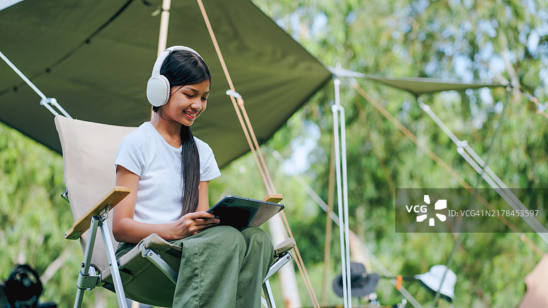 露营时使用平板电脑的亚洲女孩图片素材