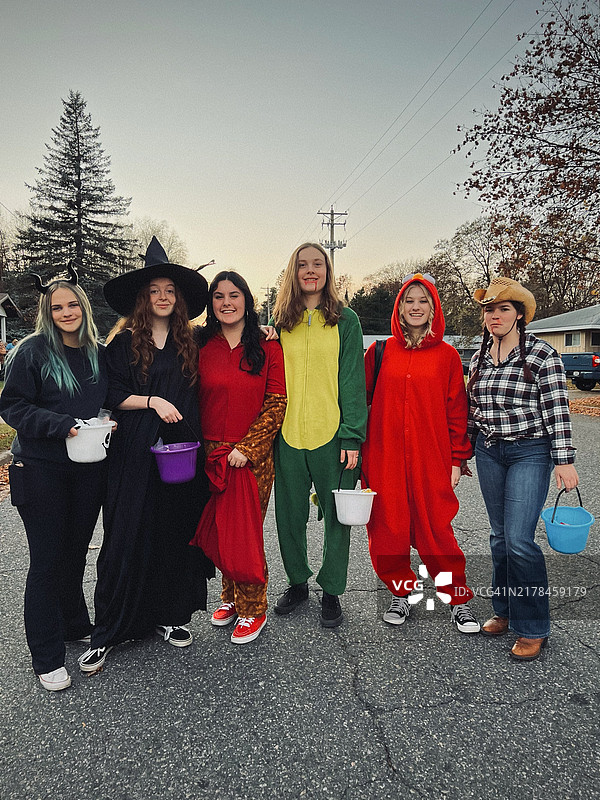 一群青少年女孩在玩“不给糖就捣蛋”游戏。图片素材