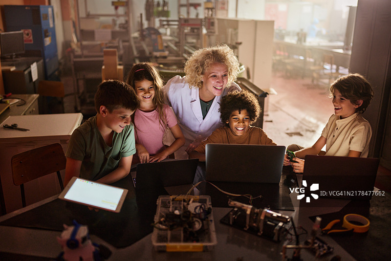 快乐的女教师和她的小程序员在实验室里图片素材