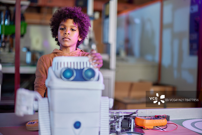 在实验室里与机器人一起工作的小科学家图片素材