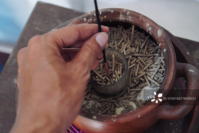 一位难以辨认的男子在家中点燃香炉的手部特写图片素材