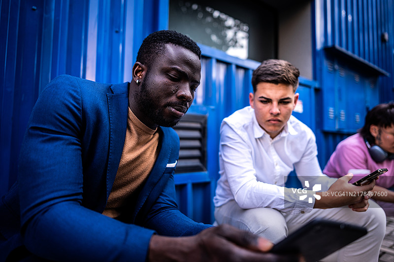 同事们在户外使用数字平板电脑图片素材