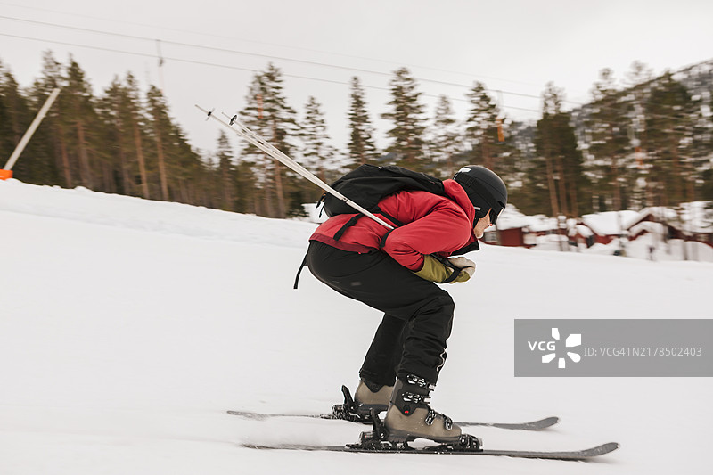一名男子在滑雪胜地滑雪下坡。图片素材