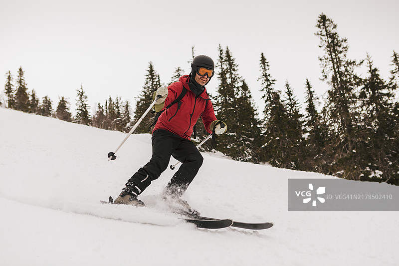 一名男子在滑雪胜地下坡滑雪。图片素材