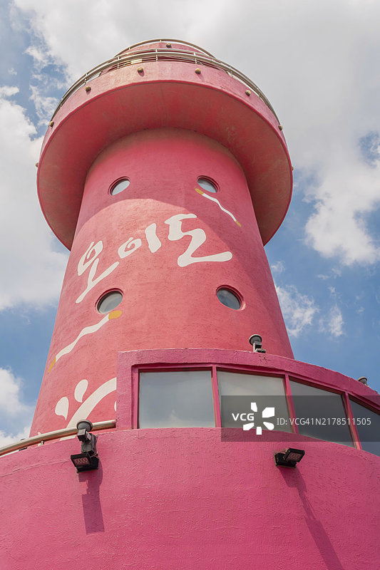 韩国乌耳岛红色灯塔特写，背景为蓝色多云天空图片素材